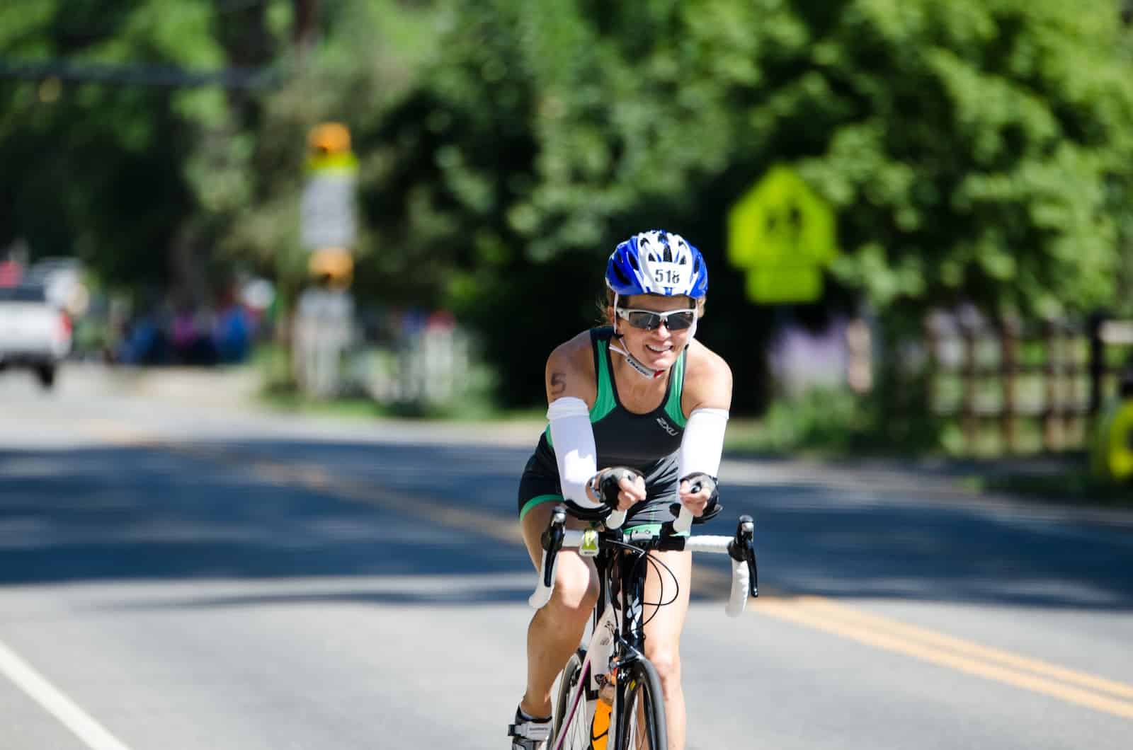 man in blue and white bicycle helmet riding on black road bike during daytime